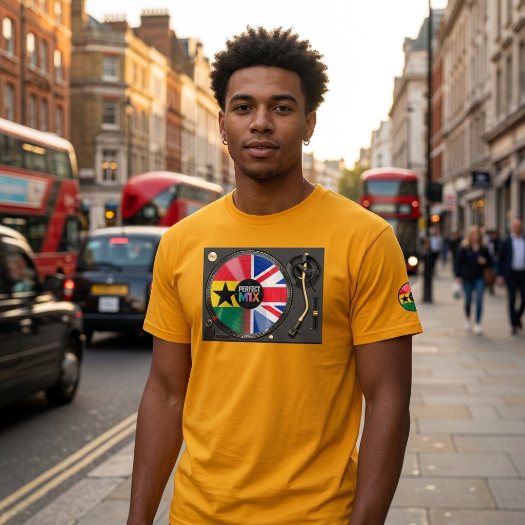 A man wearing a bright yellow t-shirt with a graphic print of a DJ turntable and the Ghanaian and British flags, standing on a city street with red London buses and black cabs in the background.
