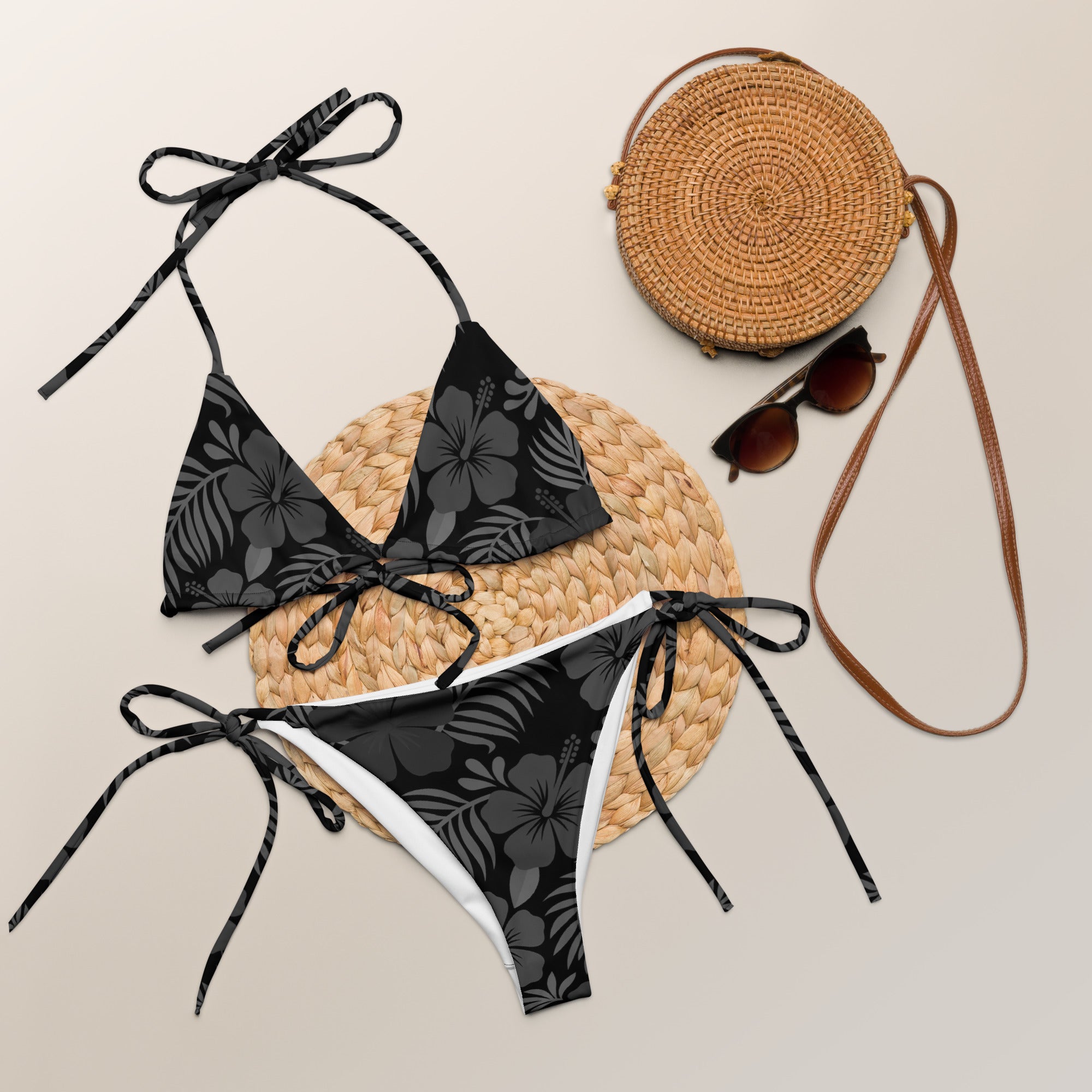 AI generated image of a Black Hibiscus pattern recycled string bikini Product shot with accessories
