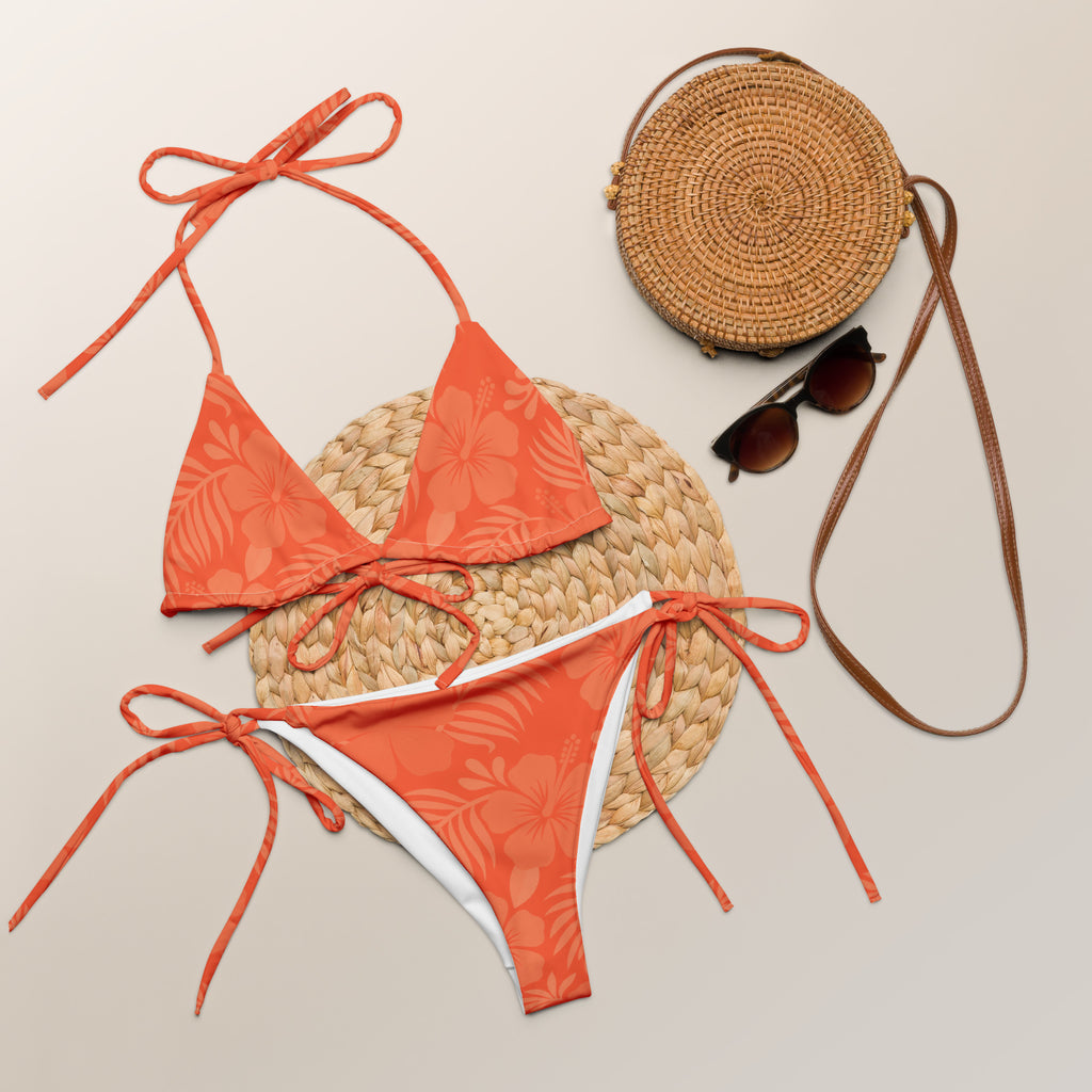 AI generated image of a Coral Hibiscus pattern recycled string bikini product shot with accessories