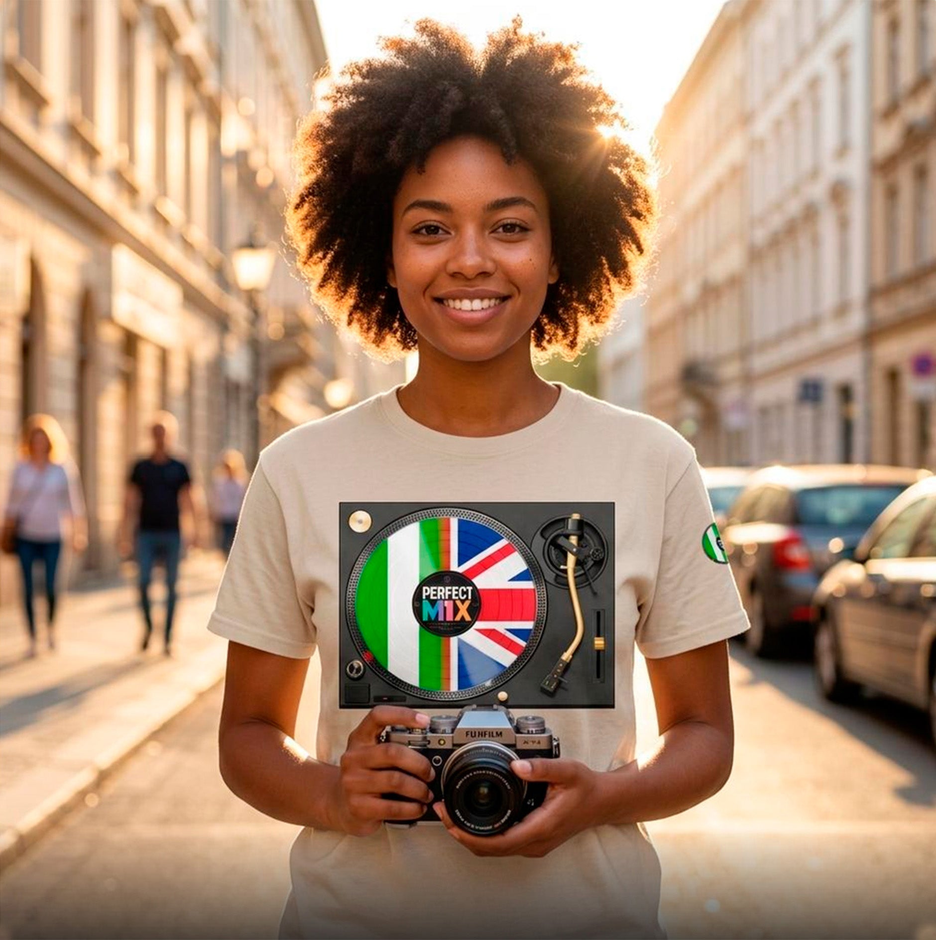 AI generated image of a smiling woman with an afro stands on a sunlit city street holding a camera, wearing a light beige T-shirt. The print shows a vinyl record design with the words 'PERFECT MIX' and and the Nigerian and British flags.