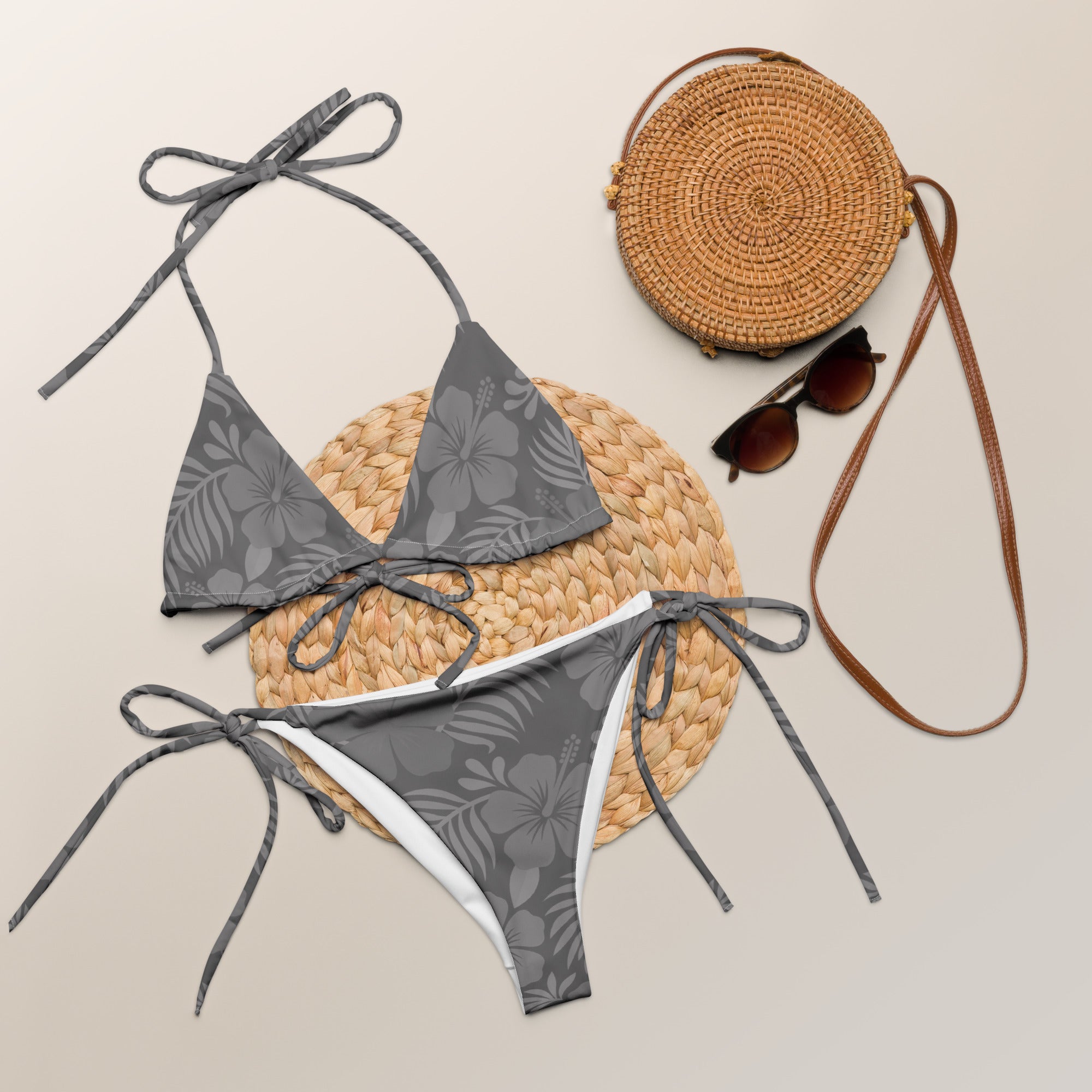AI generated image of a Silver Grey Hibiscus pattern recycled string bikini Product shot with accessories